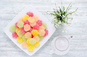 spring snowdrops and dessert fruit candy with coffee pot from top on vintage wooden