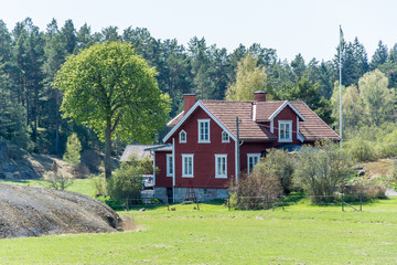 Ett rött hus med vita knutar fotat en vårdag på Värmdö © Roland