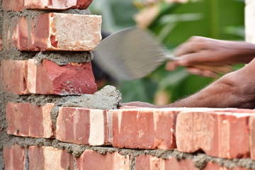 To build up a brick wall with trowel