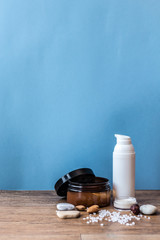 Organic cosmetic and ingredients on the blue and wooden background	