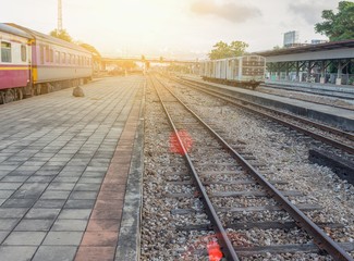 Fototapeta na wymiar railway track at station on gravel with sunset light tone.