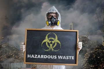 Ecology and pollution concept. Man in coveralls is warning against hazardous waste.
