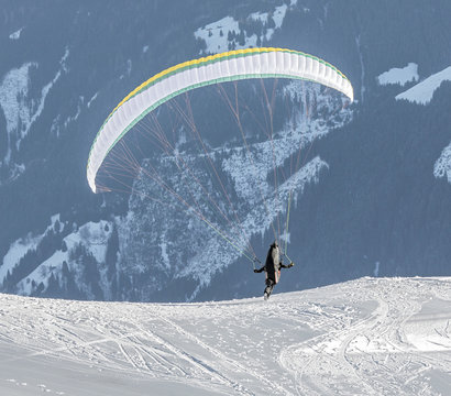 The pilot begins flight on a paraplane with a mountain-skiing slope of Penken - Mayrhofen, Austria