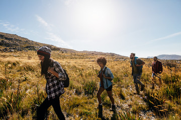 Young men and women hiking on a summer day
