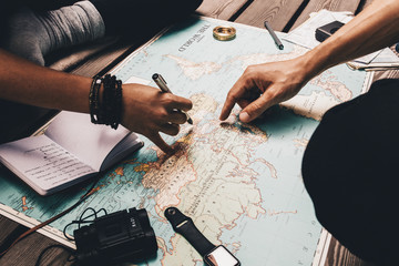 Couple planning vacation using the world map. - obrazy, fototapety, plakaty