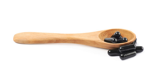 Spoon full of capsule pills isolated