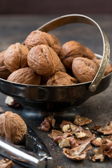  Walnuts in metal bowl .Dark grey wooden background.Dark photography.