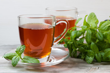 Black tea with mint. Grey wooden background.