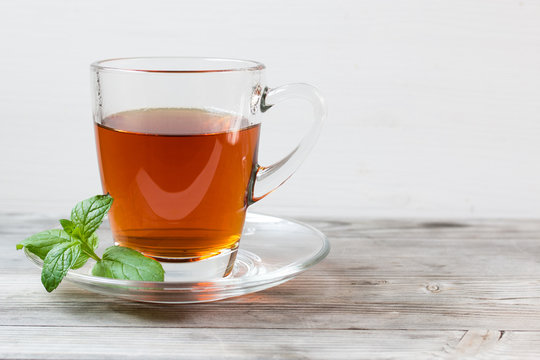 Black tea with mint. Grey wooden background.