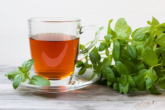 Black tea with mint. Grey wooden background.