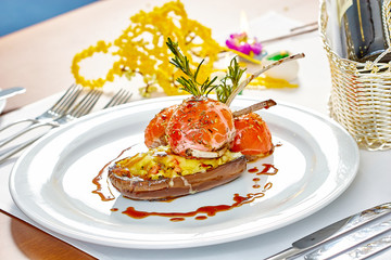 Image of lamb chops on a bed of vegetables Eggplant stuffed with vegetables