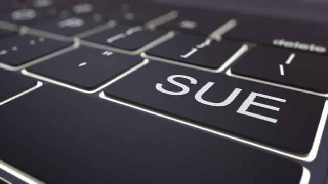 Tracking shot of modern black computer keyboard and luminous sue key. Conceptual 4K clip
