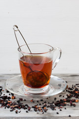 Black tea with spices.Strainer. Grey wooden background.