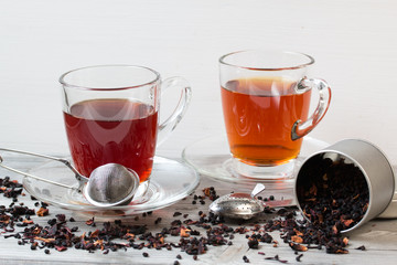 Black tea with spices.Strainer. Grey wooden background.
