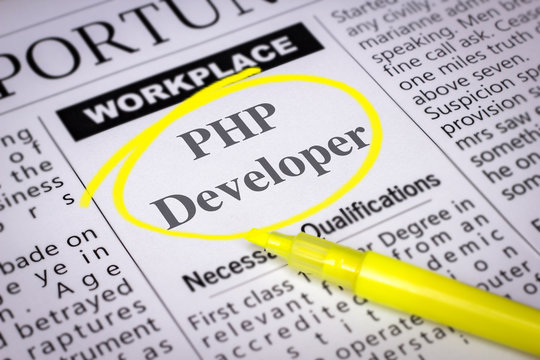 PHP Developer - Newspaper sheet with ads and job search, circled with yellow marker, Blurred image and selective focus