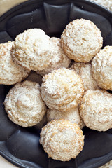 Coconut biscuits with icing sugar over pewter plate