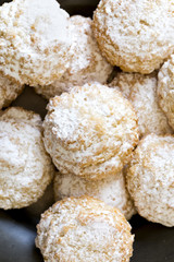 Coconut biscuits with icing sugar over pewter plate
