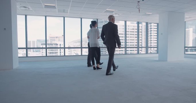 Businesspeople meeting architect at office site and  discussing interior plan. Owners discussing new interior in unfurnished empty office space.