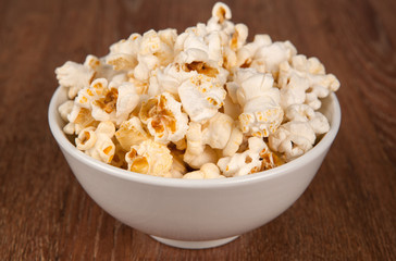 bowl filled with salt popcorn on a wooden table