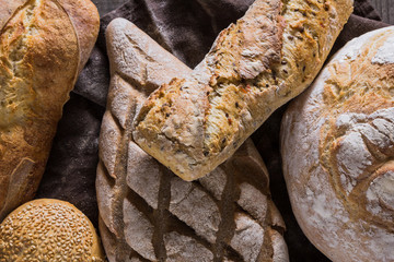 Several types of fresh bread lying on an old wooden table