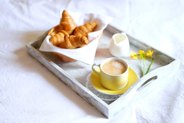 Obraz na płótnie Canvas Breakfast in bed. Gray wooden tray with croissants and tea.