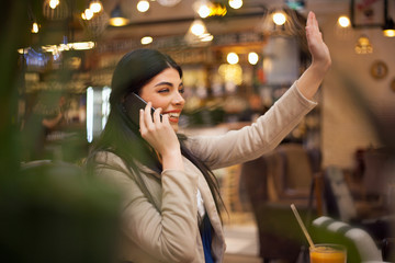 Woman using talking on cell phone at cafe
