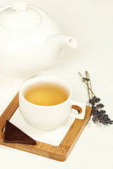 Hot tea in white cup and teapot
