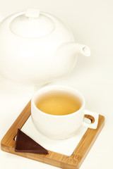 Hot tea in white cup and teapot