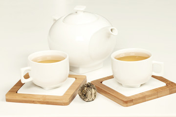 Hot tea in white cup and teapot