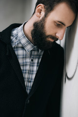 Portrait of young bearded hipster, depressed man in pain