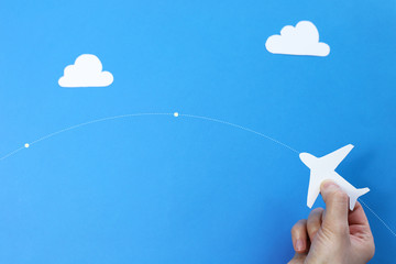 paper airplane in hands on a blue background