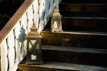 Old lantern with candles on wooden stairs