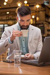 young businessman with beard in cafe on coffee break