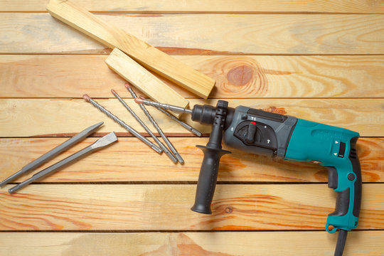 Electric hammer drill lies on a wooden table