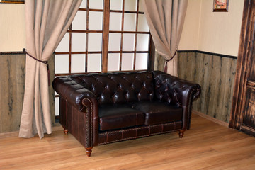 Черный кожаный диван в комнате
 - obrazy, fototapety, plakaty