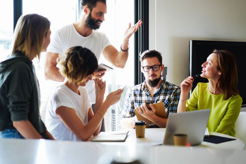 Young and successful entrepreneurs are working on the marketing project at the modern coworking...