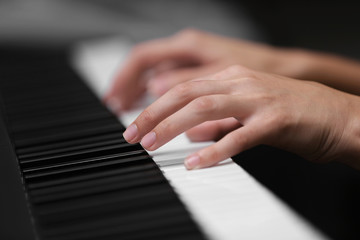 Female hands playing on synthesizer, closeup