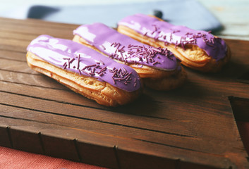 Delicious eclairs on wooden desk with a napkin