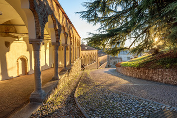 Colonnade and ancient path in the castle of Udine under the sunset light