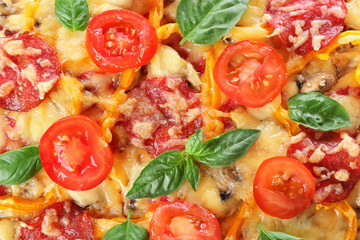 Close up view of tasty pizza with pepperoni, cheese, tomatoes, basil and salad pepper