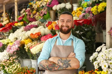 Crédence de cuisine en verre imprimé Fleuriste Handsome tattooed florist in flower shop