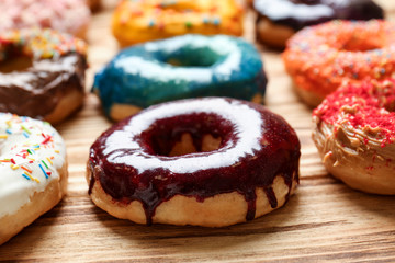Glazed donuts on wooden table, closeup