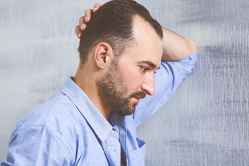 Obraz premium Handsome depressed man standing near wall at home