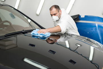 Man on a car wash polishing car with a polish machine