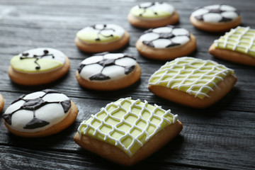 Tasty football cookies on wooden table, closeup