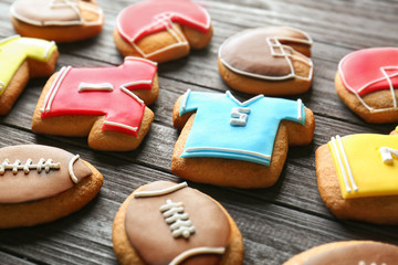Tasty football cookies on wooden table, closeup
