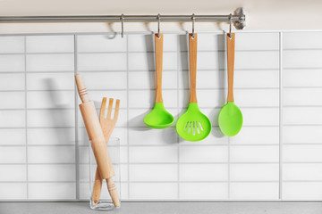 Set of wooden kitchen utensils hanging on wall