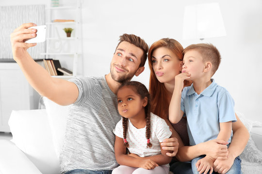 Happy interracial family making selfie at home