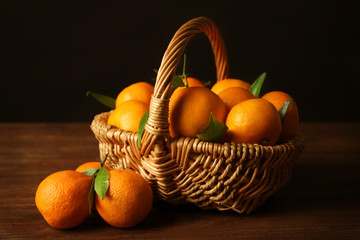 Basket with tangerines on dark background