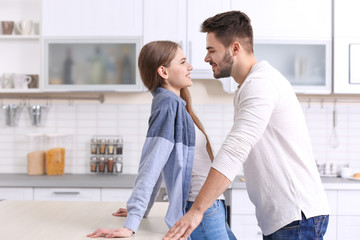 Cute young couple in kitchen at home